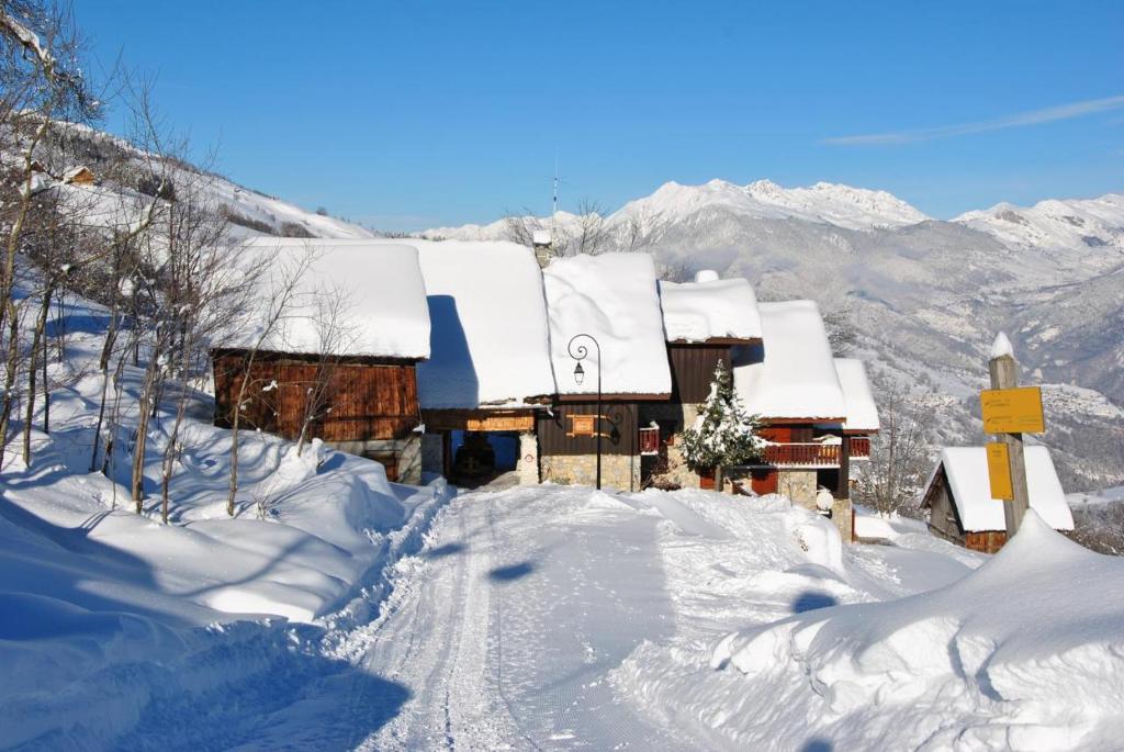 a snow covered cabin with a snow covered roof at Le MAZOT chalet Lucie in Valmorel
