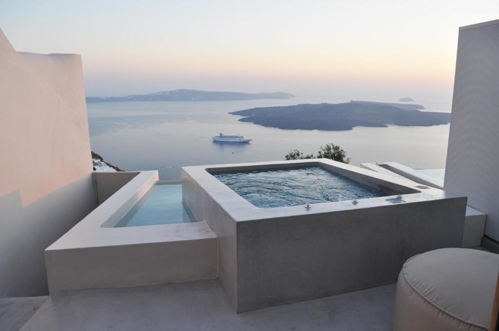 a plunge pool in a house with a view of the ocean at Aesthesis Boutique Villas Firostefani in Firostefani