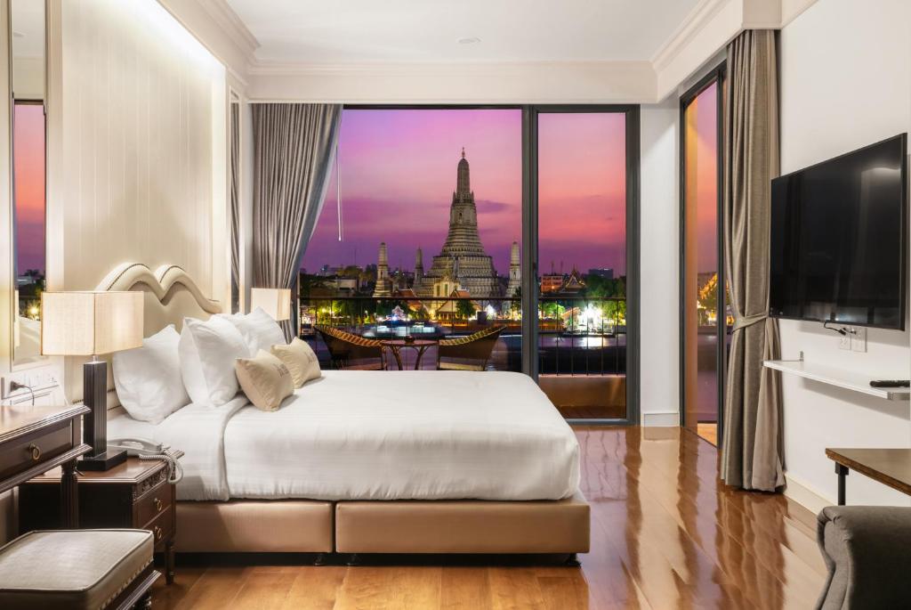 a bedroom with a bed and a view of the city at ARUN Riverside Bangkok in Bangkok