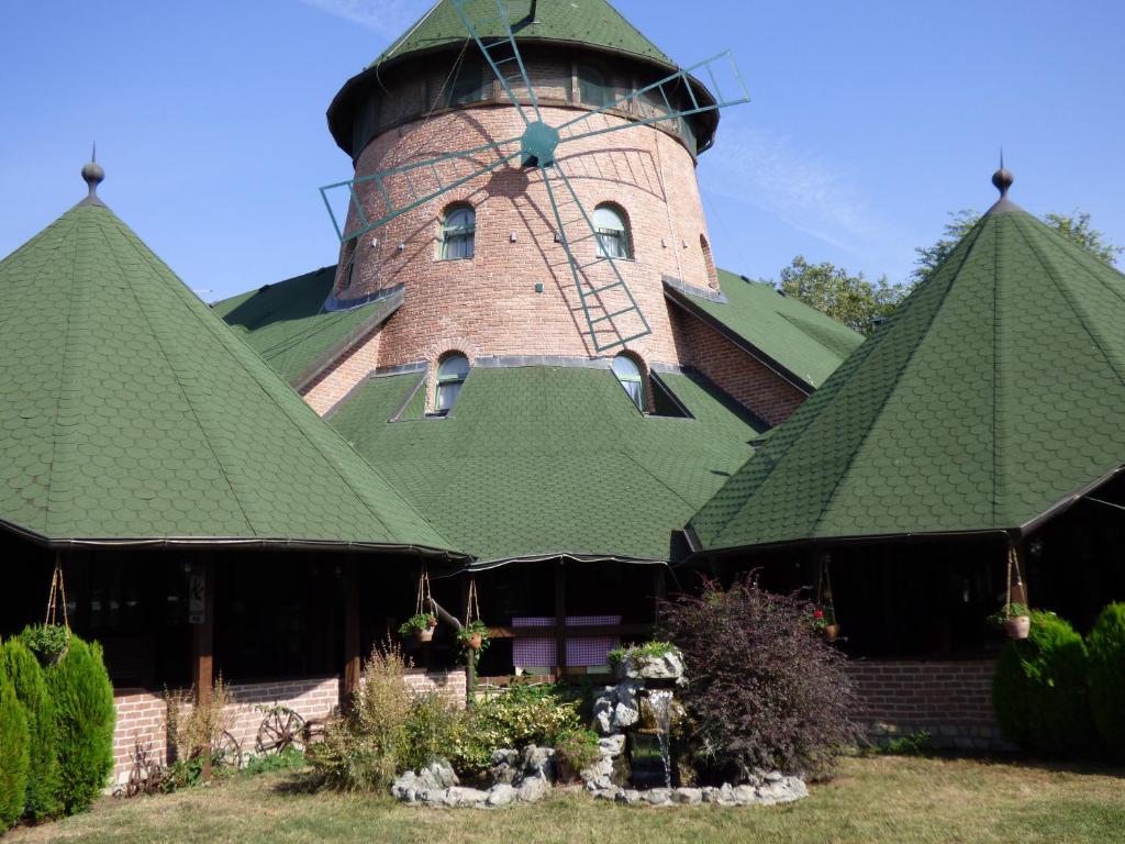 un bâtiment avec un toit vert et une tour dans l'établissement Hotel Vetrenjača, à Vršac