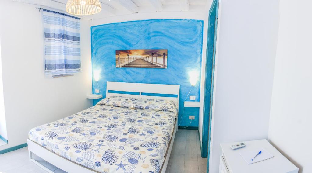 a small bedroom with a bed and a blue wall at Borgo Marino Suite B&B in Cefalù
