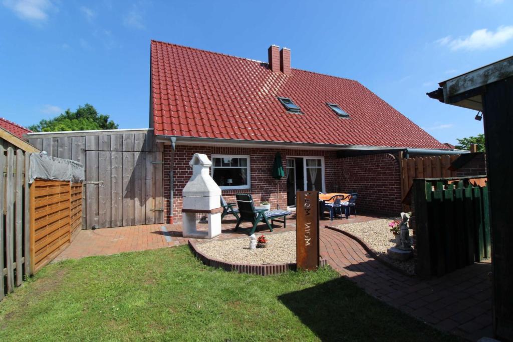 a backyard with a house with a red roof at Ferienhaus Moorspatz, 95143 in Rhauderfehn