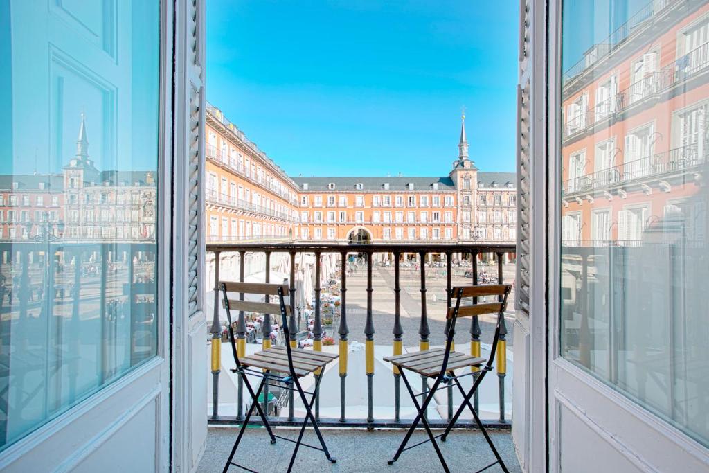 a balcony with two chairs and a view of a building at Genteel Home Plaza Mayor in Madrid