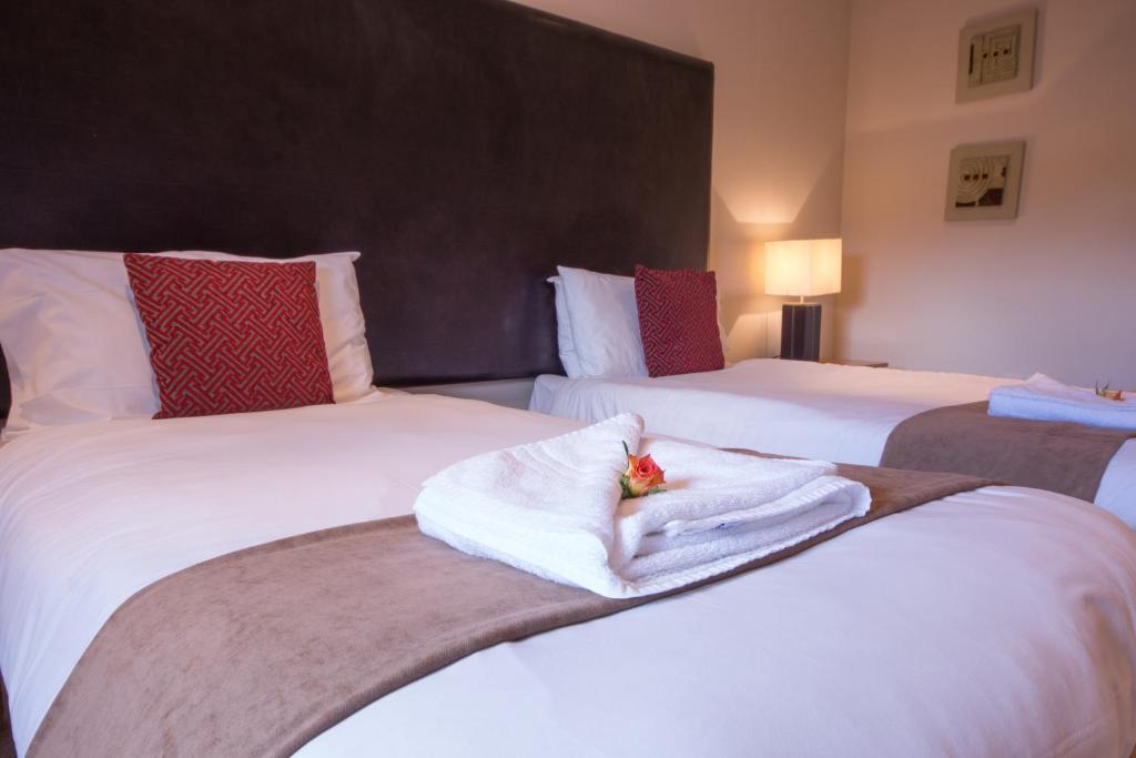 a hotel room with two beds with towels on them at Wensley Cottage - Darwin Lake Holiday Village in Matlock