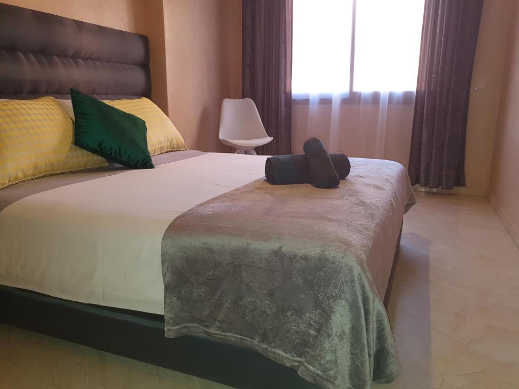 una camera da letto con un letto con un cappello nero sopra di Charming Marrakech Apartement a Marrakech