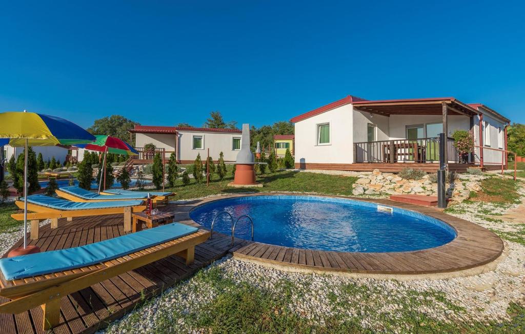 uma piscina com duas cadeiras e uma casa em Holiday Park Village Jelovci em Kringa