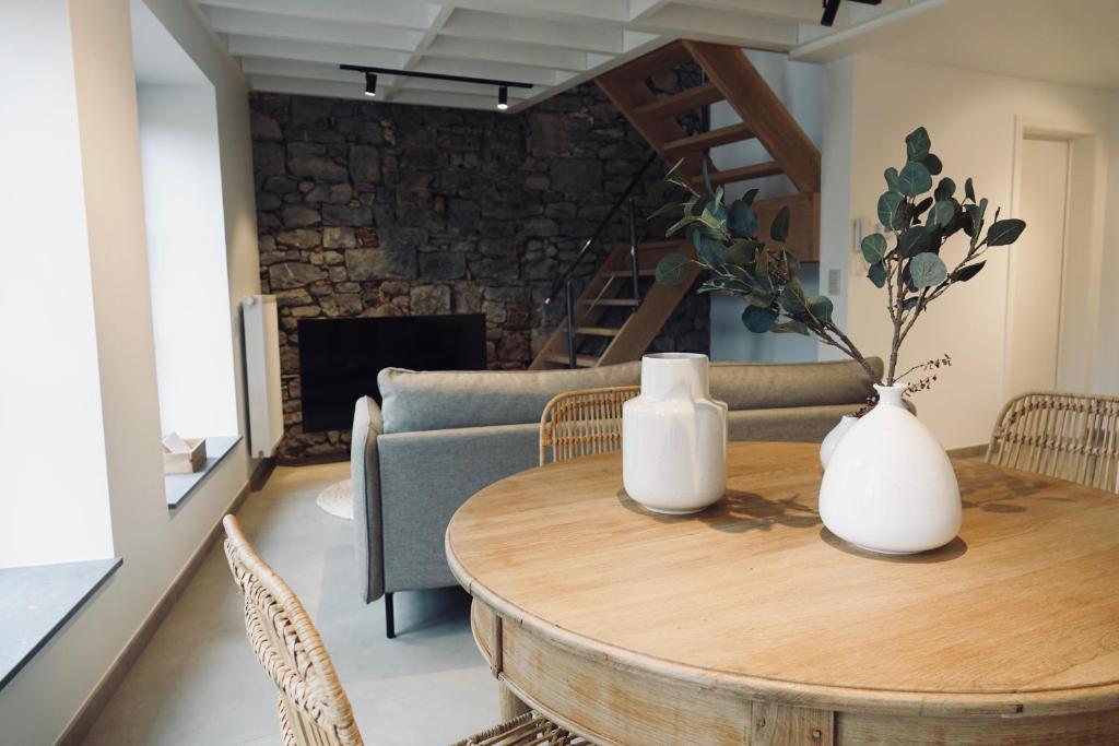 een woonkamer met een houten tafel en een bank bij Le Grand George - Résidence Le Cercle in Marche-en-Famenne