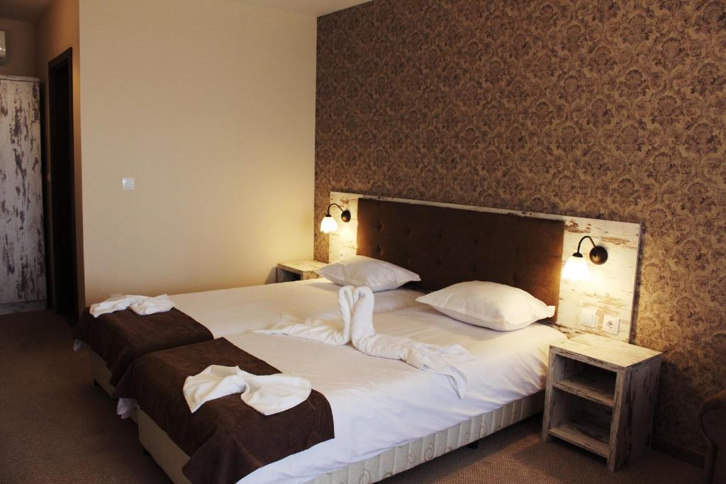 a bedroom with a large bed with white towels on it at Paraiso Theopolis - All Inclusive in Obzor