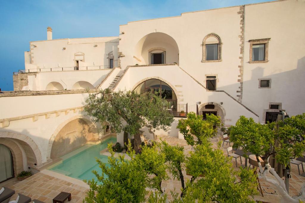 an external view of a building with a swimming pool at La Sommità Relais & Chateaux in Ostuni
