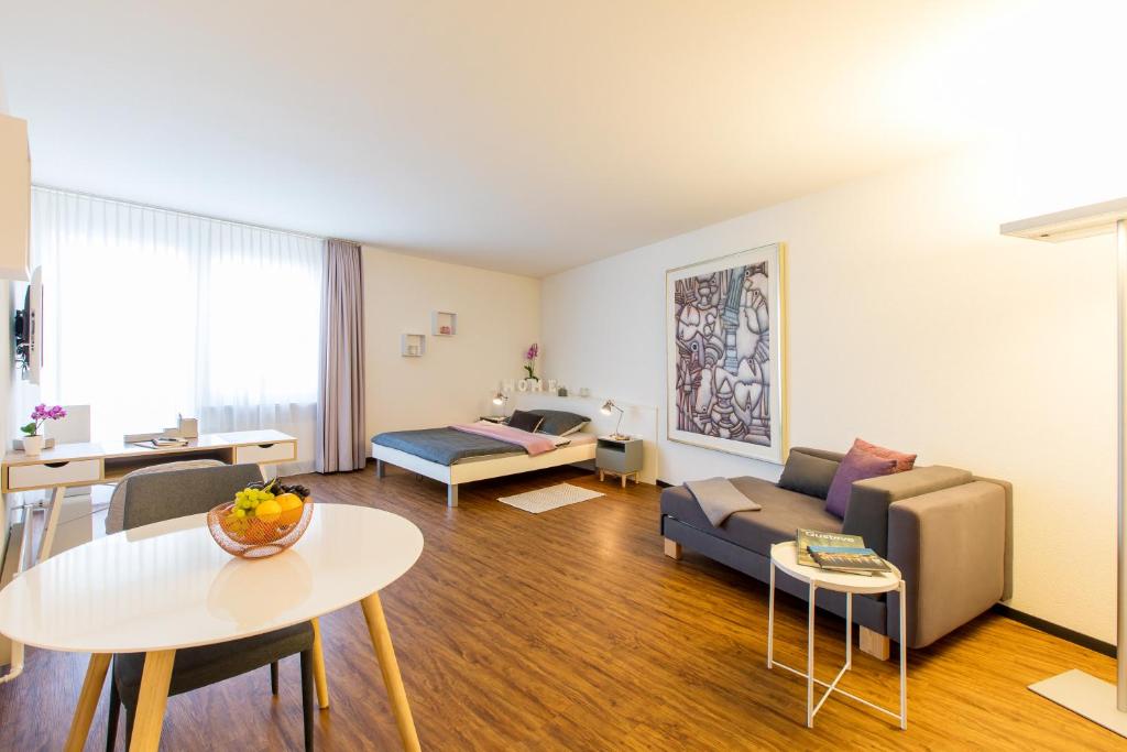 een woonkamer met een bank en een tafel bij Apartmenthaus zum Trillen Basel City Center in Bazel