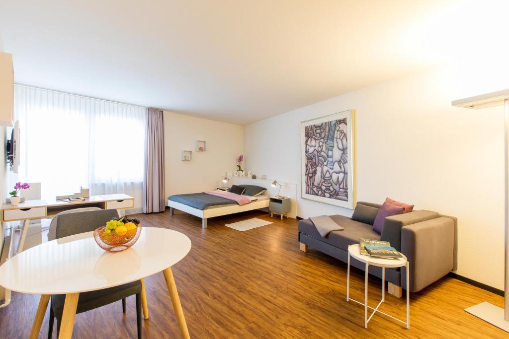 Apartmenthaus zum Trillen Basel City Center في بازل: غرفة معيشة مع أريكة وطاولة