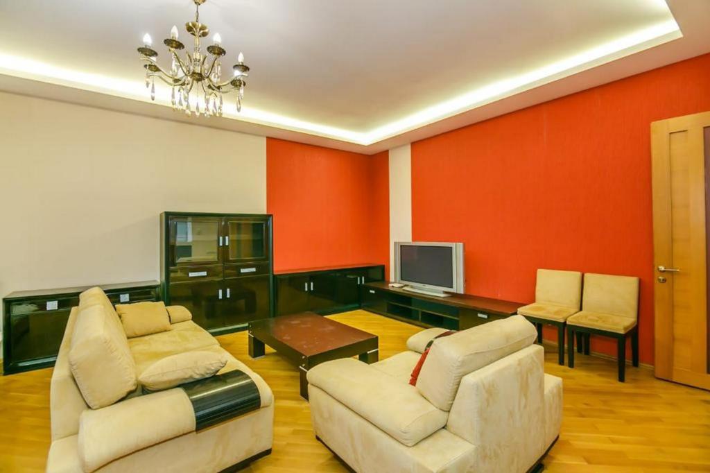 a living room with two couches and a tv at Red Apartment Vip City Center in Baku