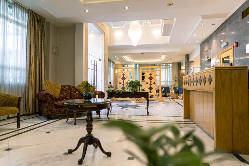 a lobby with a piano and a living room at Kindi Suite Hotel in Amman