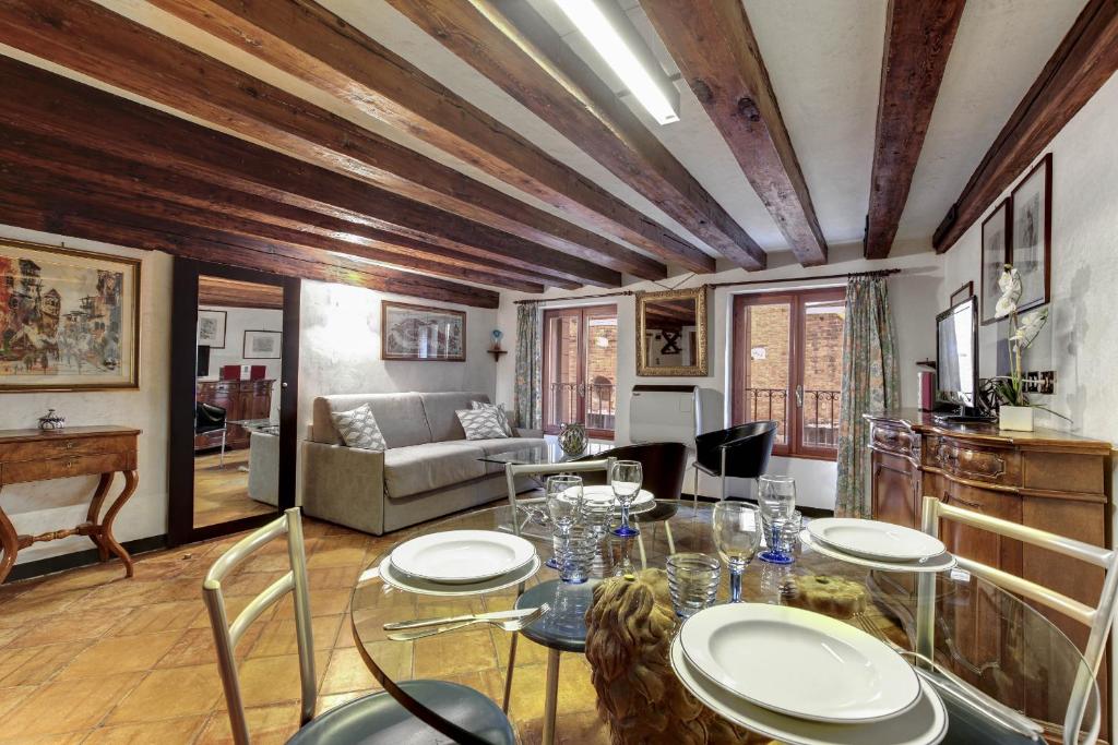 een woonkamer met een tafel en stoelen en een bank bij Canal view suite in Rialto in Venetië