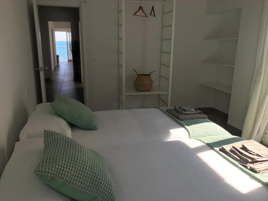 een wit bed met groene kussens in een kamer bij ALTEAMAR in Altea