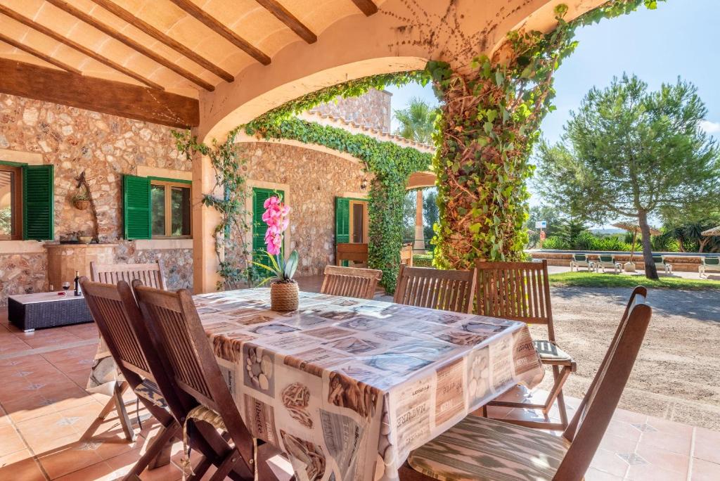 a table and chairs on a patio with an archway at Els Girasols Winter in Campos