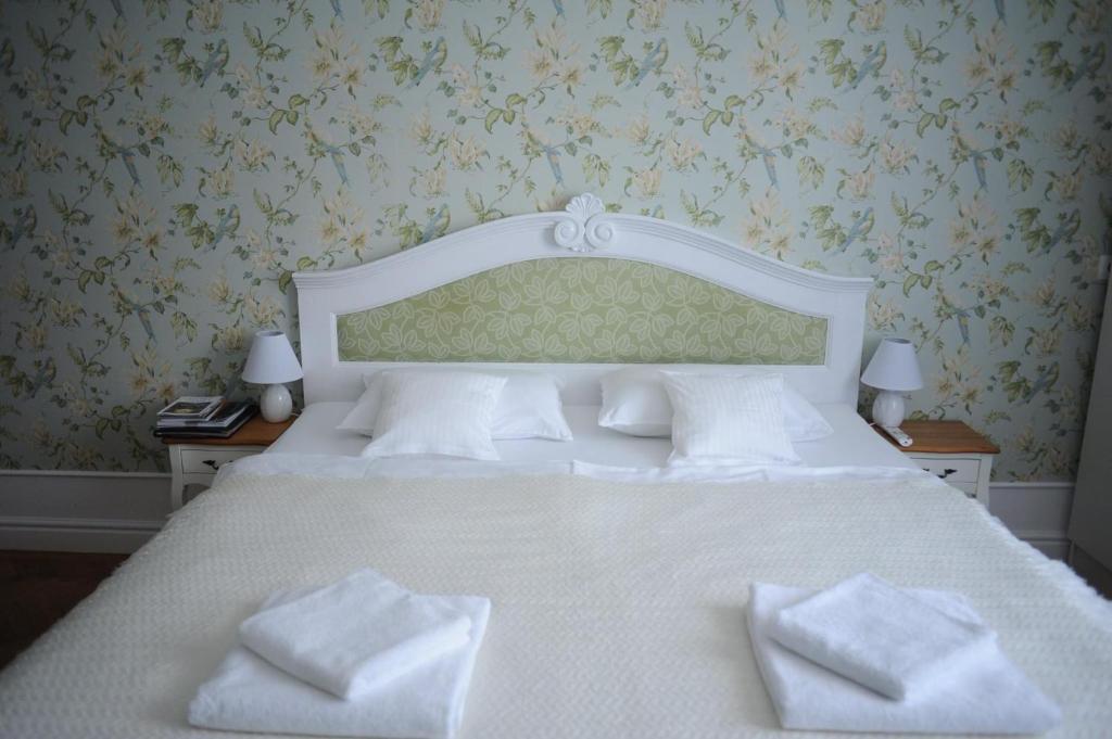 een slaapkamer met een wit bed en 2 witte kussens bij Sophie Apartment in Oradea