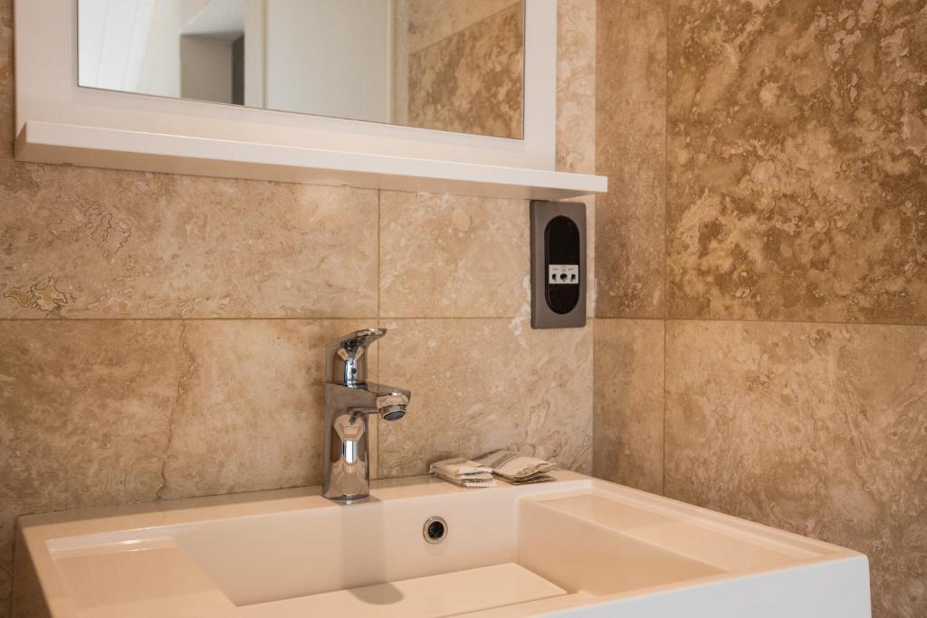 a bathroom sink with a faucet and a mirror at Centr'Hotel in Marigot