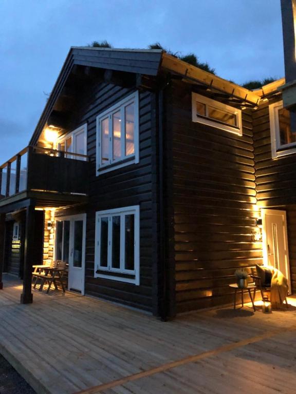 a wooden house with a deck in front of it at Årebjørnen - Sadelen in Åre