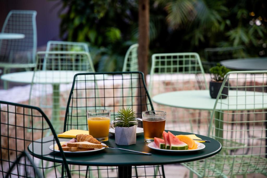 a table with two glasses of orange juice and fruit at Centr'Hotel in Marigot