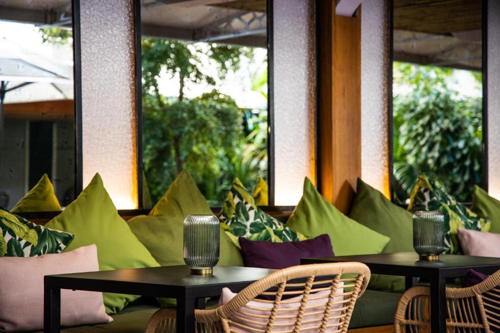 a seating area with colorful pillows and tables at Centr'Hotel in Marigot