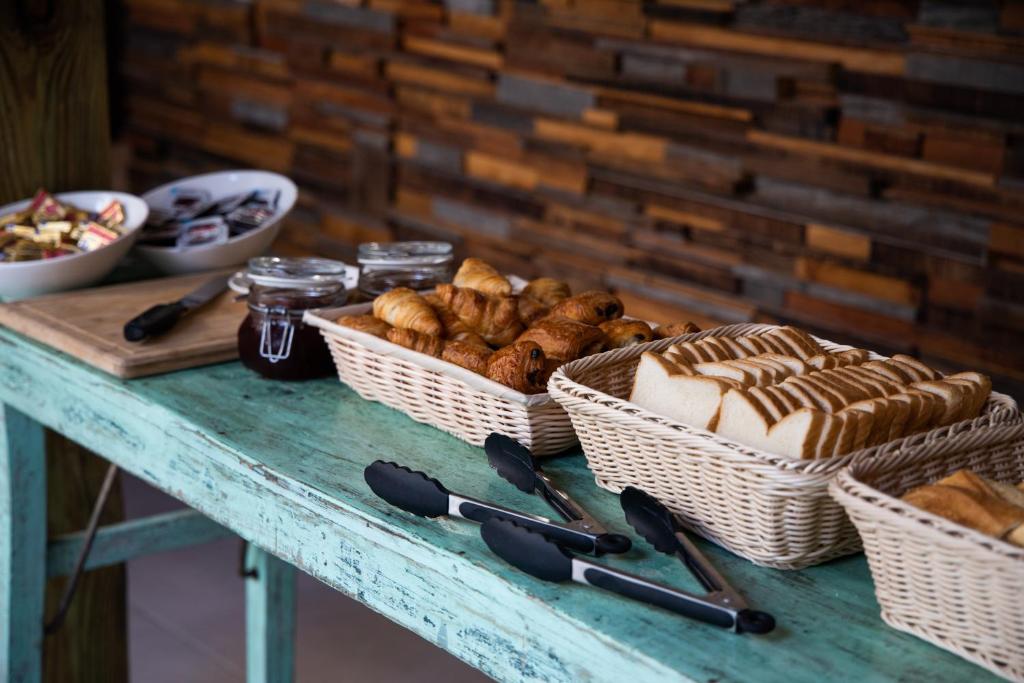 a table with baskets of bread and pastries on it at Centr'Hotel in Marigot