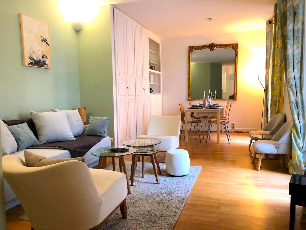 ein Wohnzimmer mit einem Sofa und einem Tisch in der Unterkunft L'appartement Magdebourg in Paris