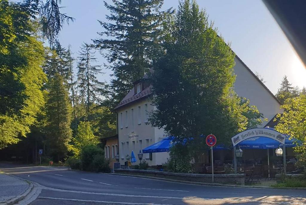 un edificio al lado de una calle con un cartel en Hotel Berggasthof Waldlust, en Wunsiedel