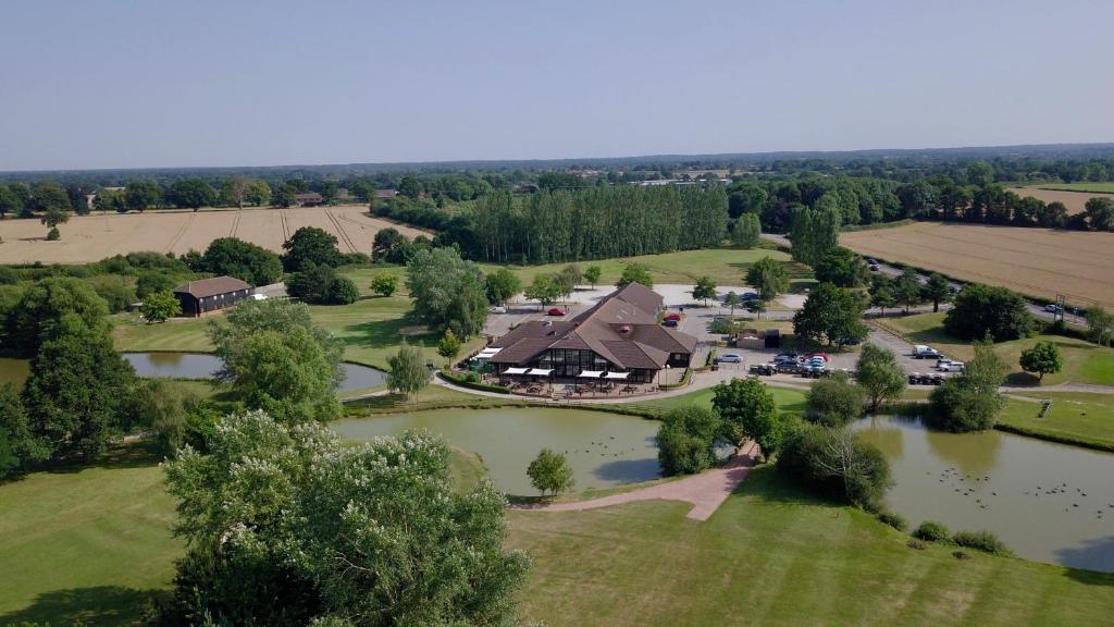 an aerial view of a house and a river at Weald of Kent Golf Course and Hotel in Headcorn