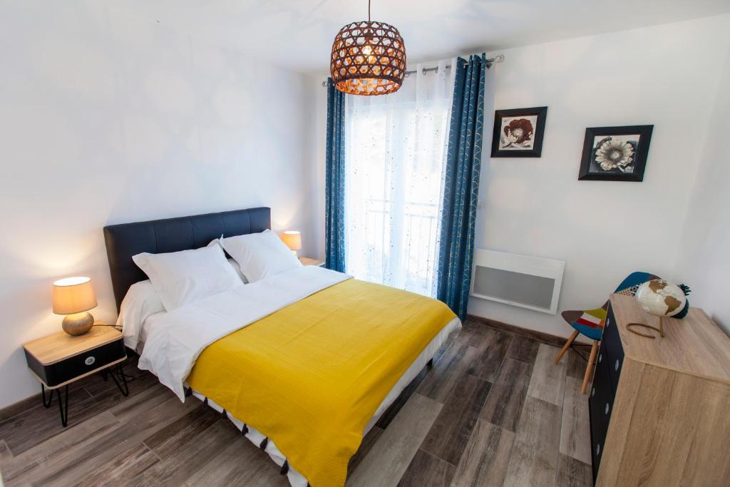 een slaapkamer met een groot bed en een gele deken bij Gîte le Haut Rivage in Tournavaux