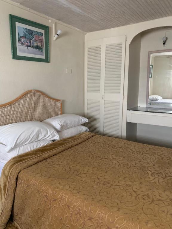 a bedroom with two beds and a mirror at Beach Vue Barbados in Bridgetown