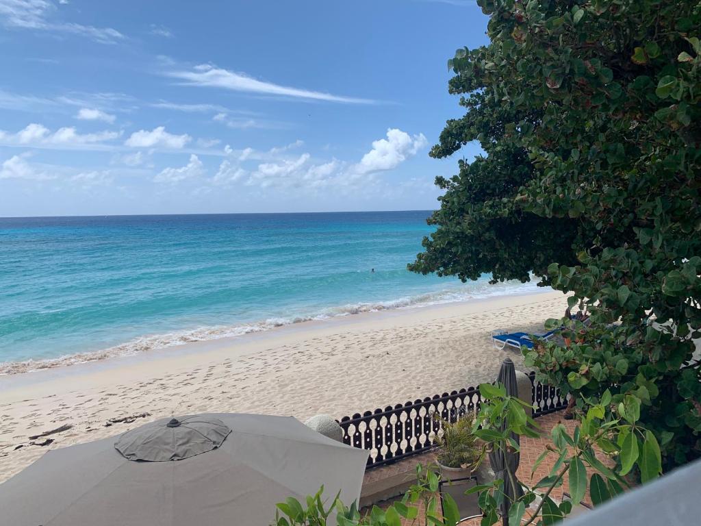 a view of a beach with an umbrella and the ocean at Beach Vue Barbados in Bridgetown