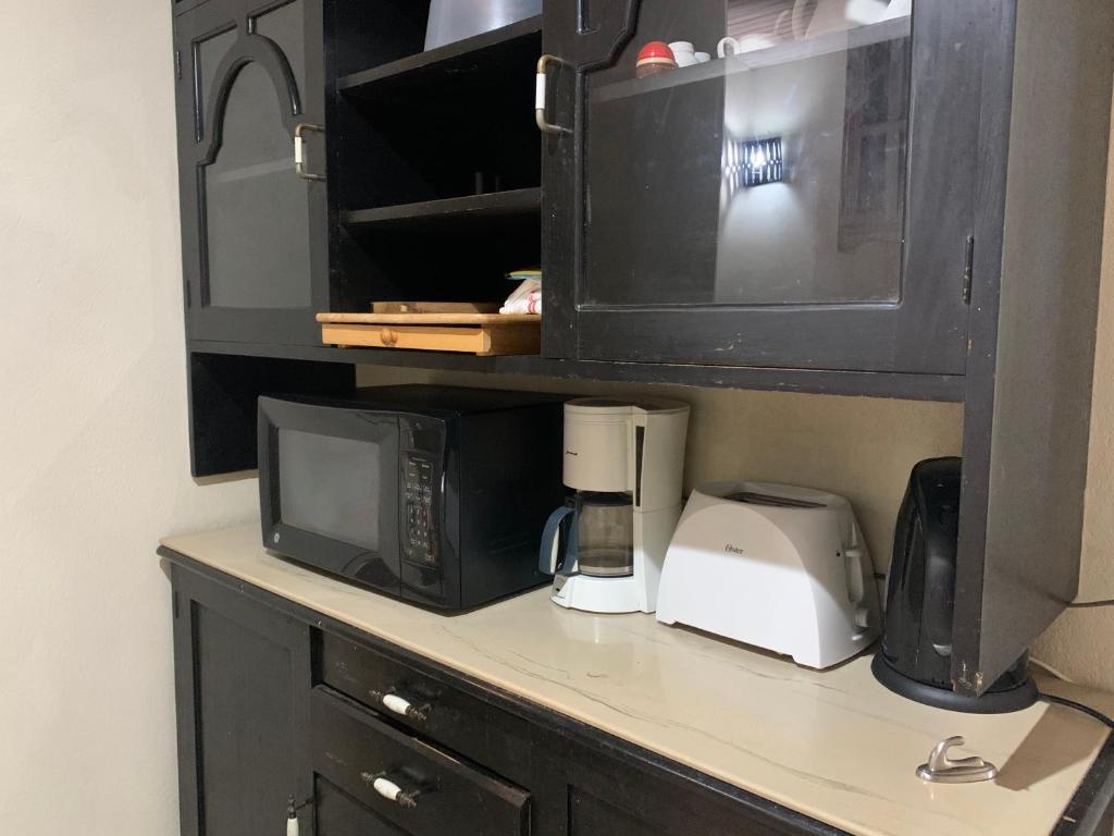a kitchen counter with a microwave and a coffee maker at Beach Vue Barbados in Bridgetown