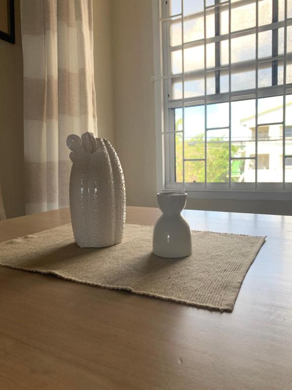 two vases sitting on a table with a window at Beach Vue Barbados in Bridgetown