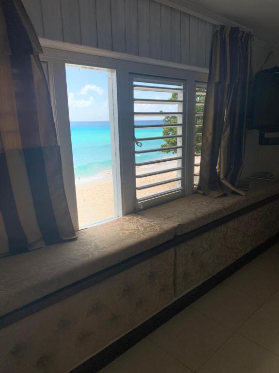 a window with a view of the beach at Beach Vue Barbados in Bridgetown
