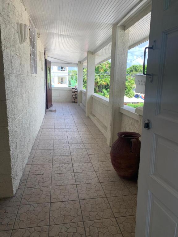 a hallway with a door and a vase on the floor at Beach Vue Barbados in Bridgetown