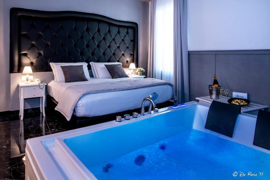 une chambre d'hôtel avec un lit et une baignoire avec un lit dans l'établissement Villa Elisio Hotel & Spa, à Naples