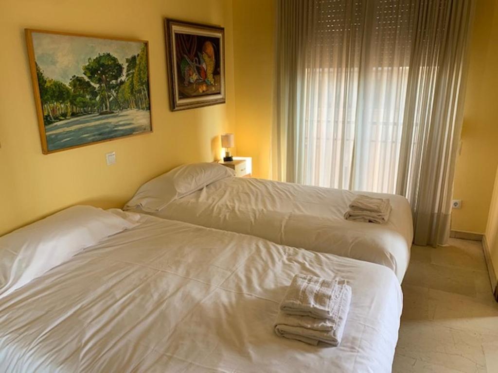 two beds in a hotel room with towels on them at Apartamentos Torr en Prosperidad - Chamartín in Madrid