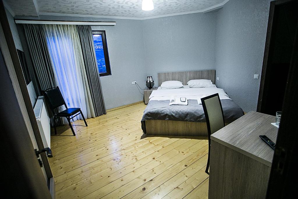 a hotel room with a bed and a desk at Soncho Kazbegi in Stepantsminda