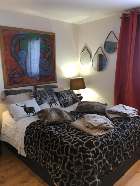 ein Schlafzimmer mit einem Bett mit zwei Katzen darauf in der Unterkunft L’énergie Tranquillisante in Le Grand-Bornand