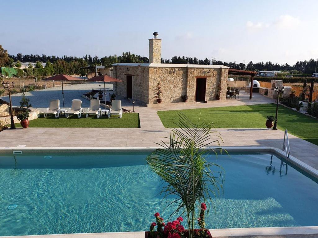 a large swimming pool in front of a building at Villa Yioukkas in Paphos