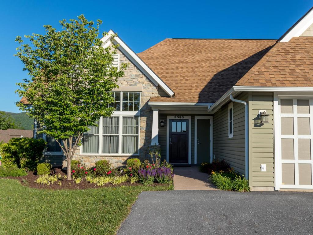 a house with a tree and a driveway at Massanutten's Regal Vistas by TripForth in McGaheysville