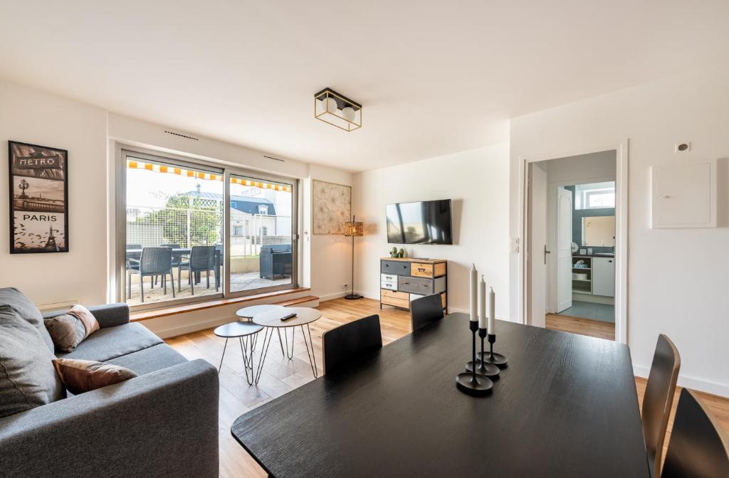 un salon avec un canapé et une table dans l'établissement Paris Champs-Elysées/Neuilly 2 pièces avec terrasse, à Neuilly-sur-Seine