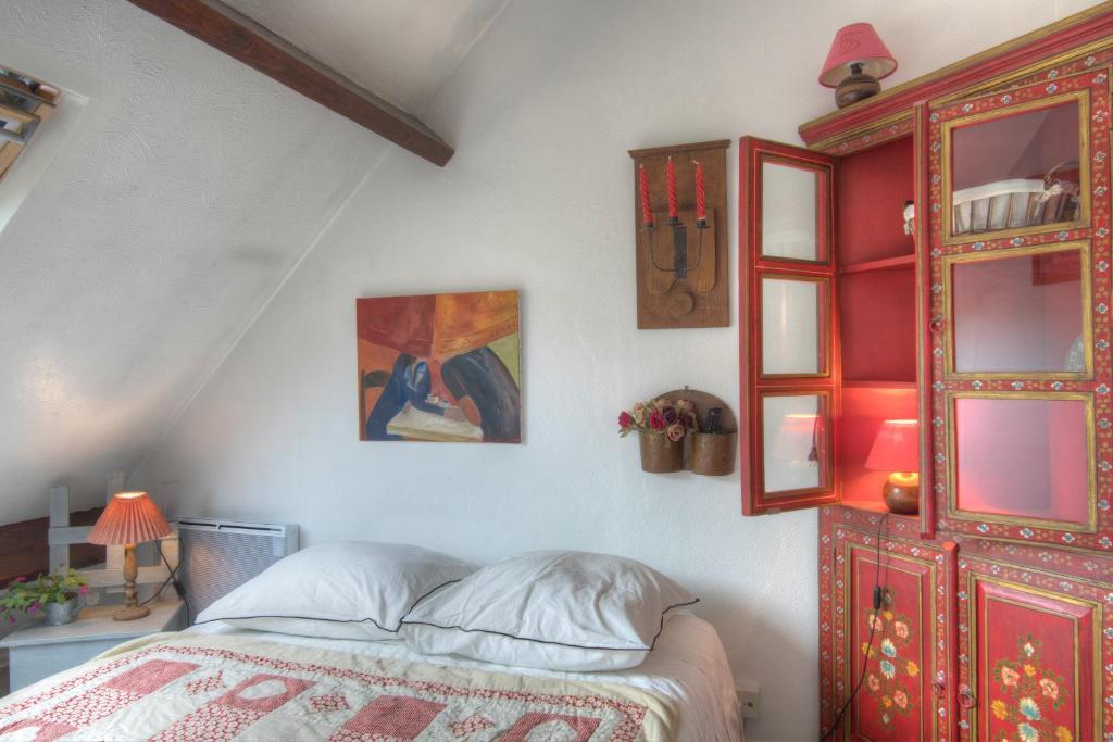 a bedroom with a bed and a red cabinet at Cottage Prairie Bonheur in Magny-les-Hameaux