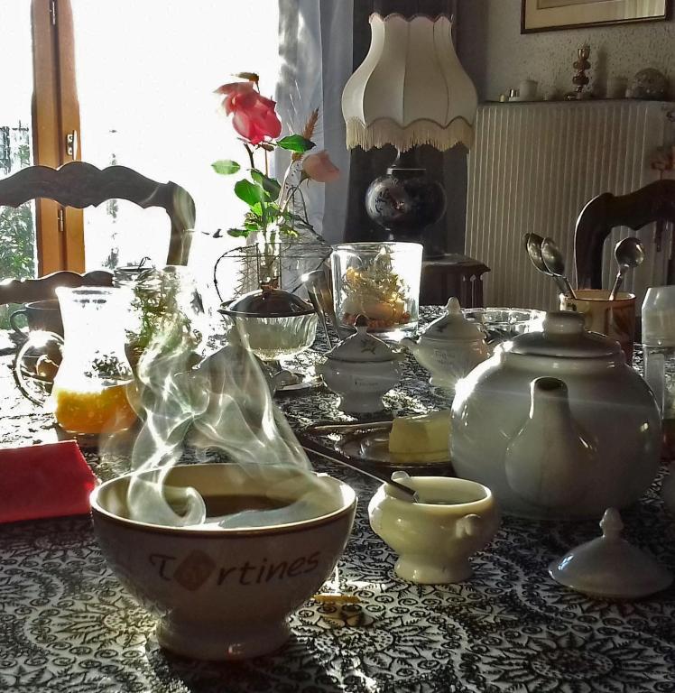 une table avec de la vaisselle et un bol de nourriture dans l'établissement Chambres d'hôtes La Hulotte 69, à Villechenève