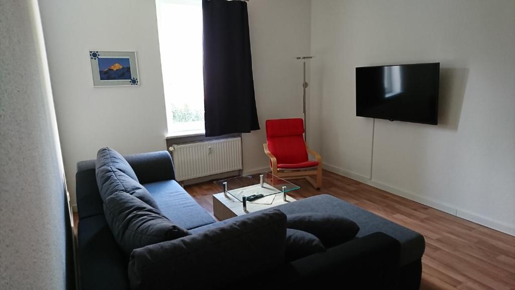 a living room with a couch and a tv at Ruhige Wohnung bei der Burg im OG1 in Kröllwitz