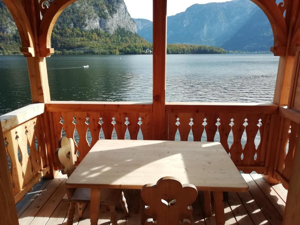 a table on a deck with a view of a lake at Seehaus am Hallstätter See in Hallstatt
