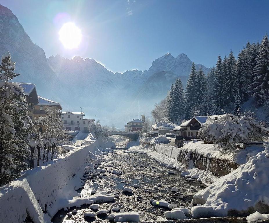 rzeka pokryta śniegiem z górami w tle w obiekcie All'Amicizia w mieście Santo Stefano di Cadore