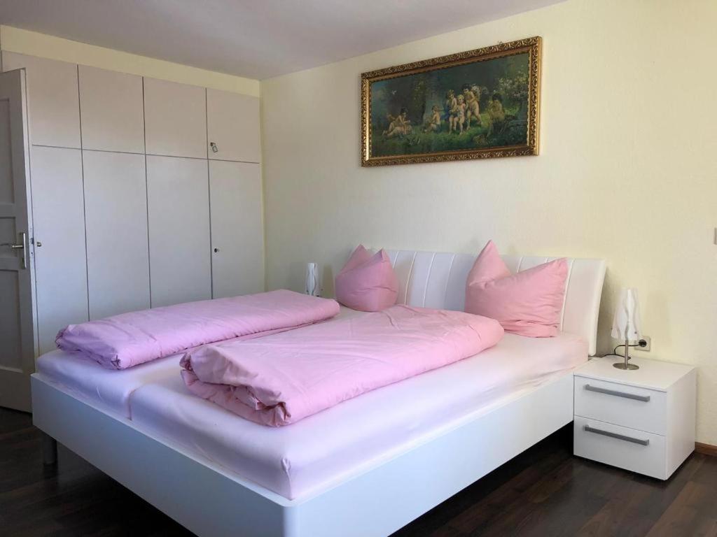 a white bed with pink pillows on top of it at Gasthaus Adler Weilheim Waldshut-Tiengen in Weilheim
