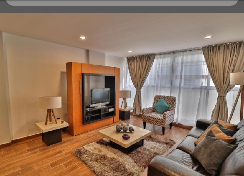 een woonkamer met een bank en een tv bij Vive la Roma, ubicación ideal in Mexico-Stad